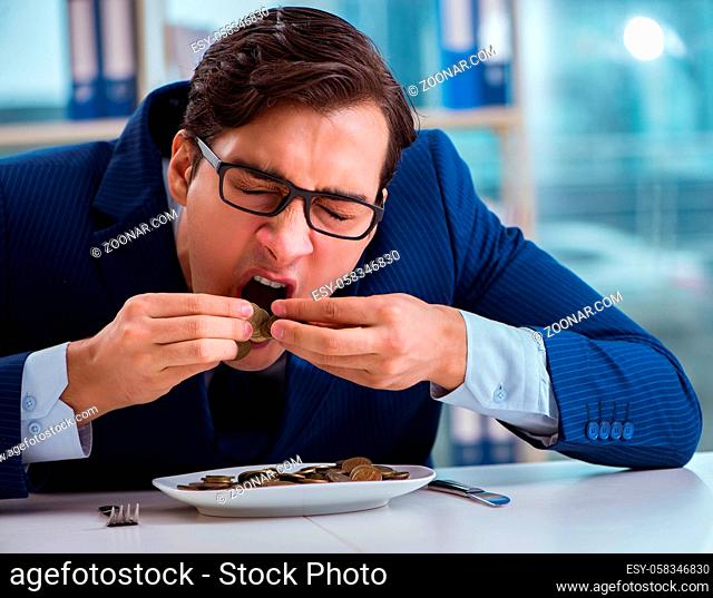 The funny businessman eating gold coins in office