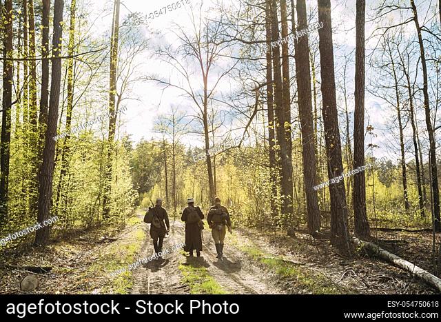 Group Of Re-enactors Dressed As Soviet Russian Red Army Infantry Soldiers Of World War II Marching Along Forest Road At Spring Season