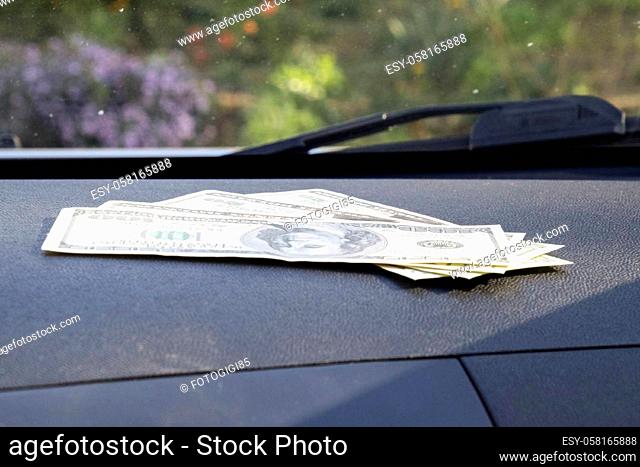 Dollars on a car dashboard under the windshield. American Money