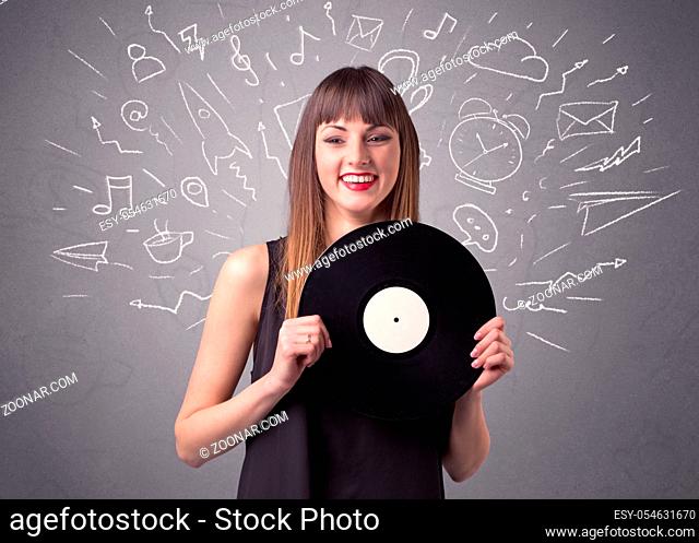 Young lady holding vinyl record on a grey background with mixed scribbles behind her