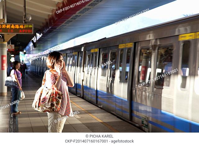 A woman on a phone waiting for an arriving train at the Shilin Metro (MRT) Station on July 7, 2014 in Taipei, Taiwan. (CTK Photo/Karel Picha)