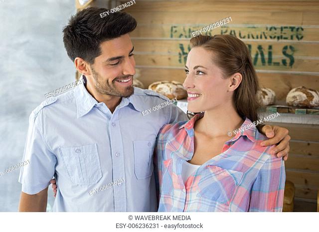 Couple with arm around at bakery