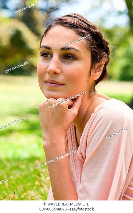 Woman looking into the distance while resting her head on her fist