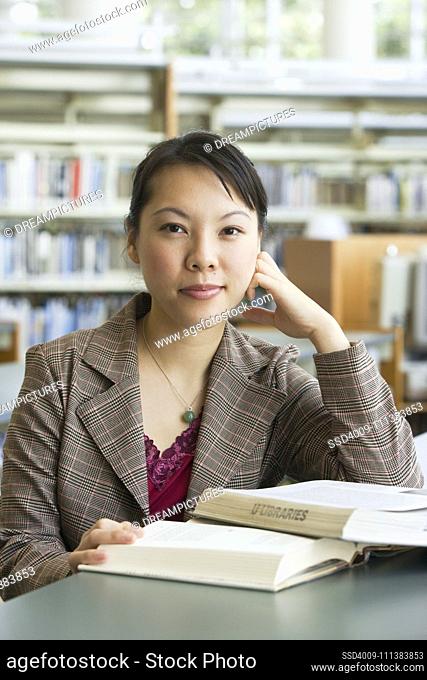 Asian woman with books in library