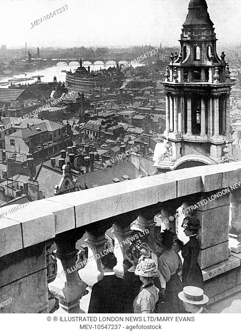 Visitors to St. Paul's Cathedral in the City of London look across London from its roof towards the River Thames and Westminster Abbey
