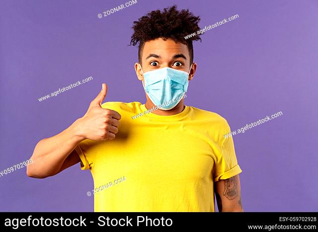 Covid19, healtcare and medicine concept. Excited young hispanic man in facial mask taking care of health, avoid public places