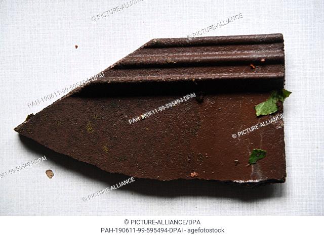 11 June 2019, Bavaria, München -Neuaubing: A brick of a house in Neuaubing, damaged by hail, lies on a kitchen table. Craftsmen will have to repair the damage...