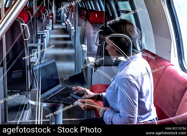 Business Woman Working on Laptop and Smartphone in First Class in a Train in Switzerland