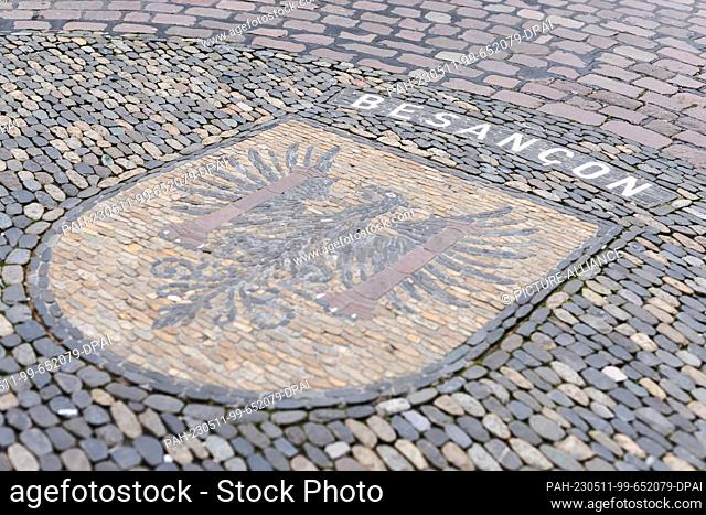 11 May 2023, Baden-Württemberg, Freiburg: The coat of arms of Freiburg's twin city Besançon is embedded in the pavement on the town hall square