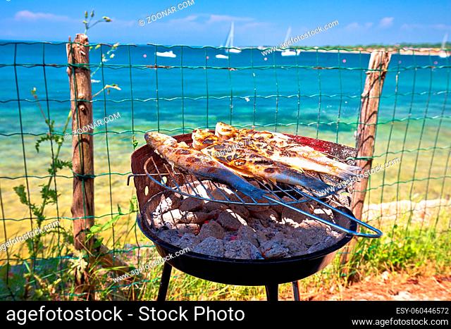 Fish on the grill by the mediterranean beach, idyllic vacation food preparing, Istria region of Croatia