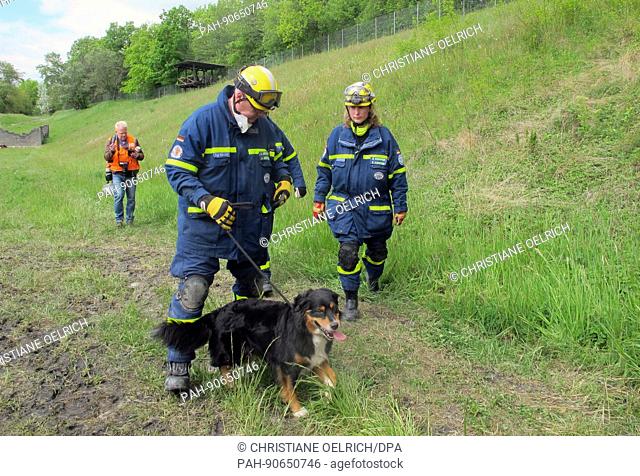 Johannes Arnoldi (c) of the German Federal Agency for Technical Relief (THW) and search dog Cash participate in an earthquake drill in Epeisses near Geneva