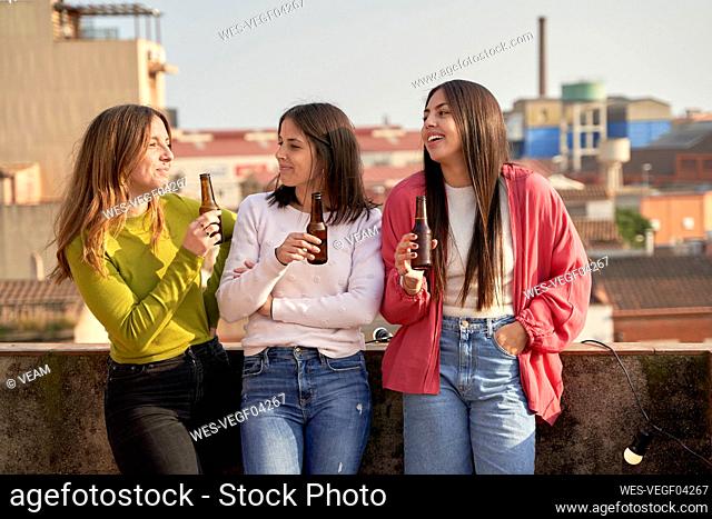 Female friends drinking beer on rooftop