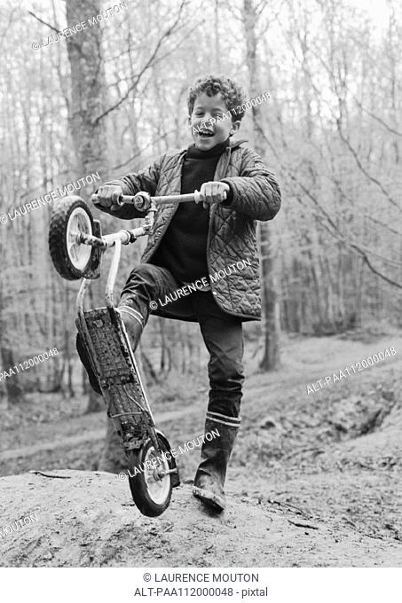 Boy holding scooter, b&w