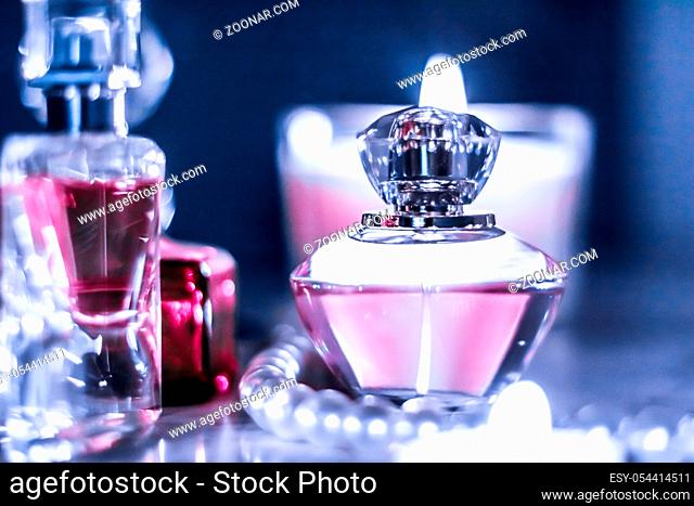 Perfumery, cosmetics branding and luxe concept - Perfume bottle and vintage fragrance on glamour vanity table at night, pearls jewellery and eau de parfum as...