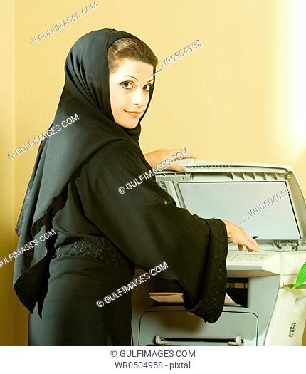 Young businesswoman using photocopier