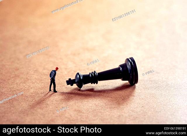Pensive businessman looking at chess figure