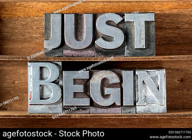 just begin phrase made from metallic letterpress type on wooden tray