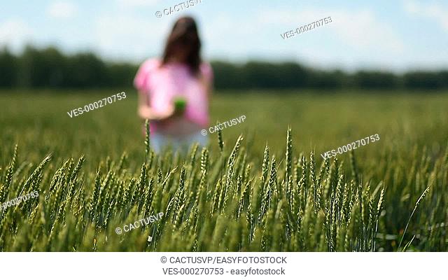 Young woman making selfies in green wheat field