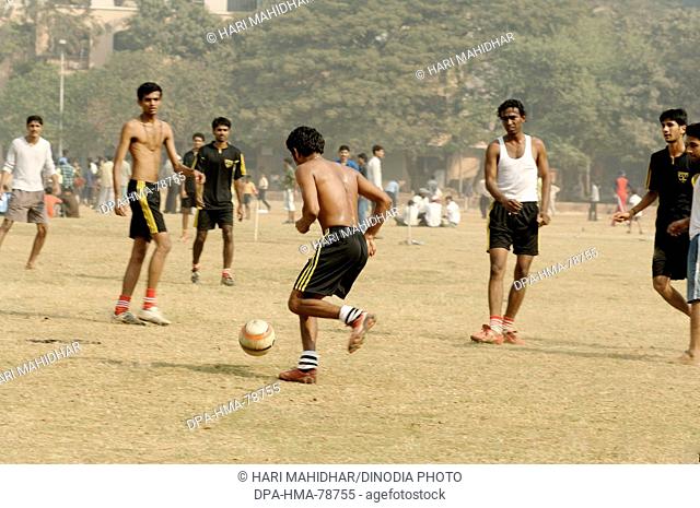 Indian boys playing football on playground ; Bombay Mumbai ;  Maharashtra ; India