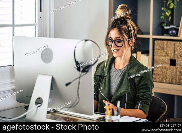 Happy adult young woman in video call conference at home in smart working free alternative office job lifestyle - pretty female people receive news on laptop...