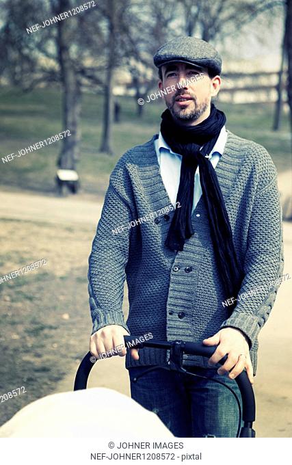 Man in park with baby carriage