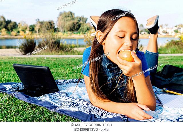 Girl enjoying apple, Long Beach, California, US