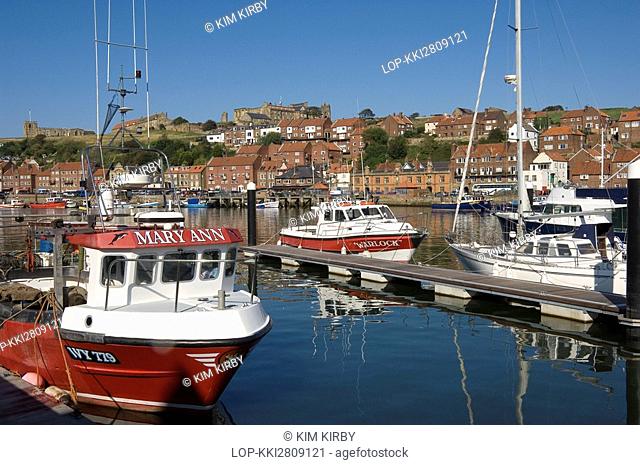 England, North Yorkshire, Whitby, Fishing boats in Whitby Harbour with the church of St Marys in the background
