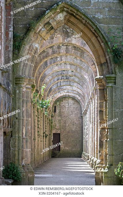 Rows of arches recede behind a lancet doorway within the remains of Fountains Abbey, Ripon , Yorkshire, UK