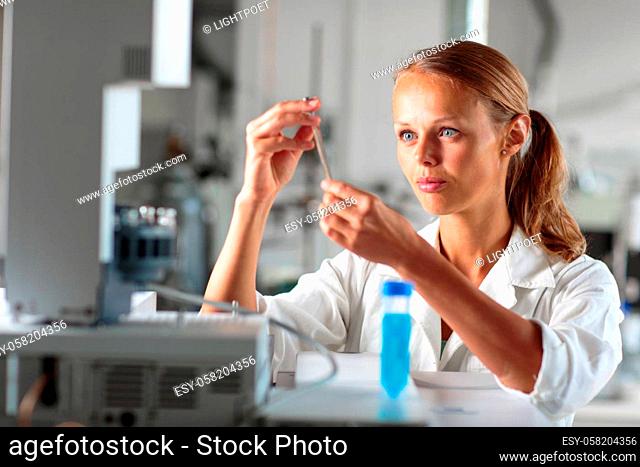 Portrait of a female researcher doing research in a lab, using a tablet computer for data collection and visualization(shallow DOF; color toned image)