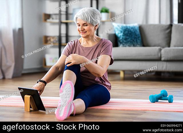 happy woman with tablet pc exercising at home