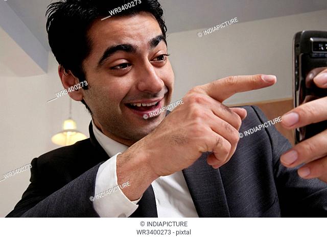 Businessman pointing at his mobile phone