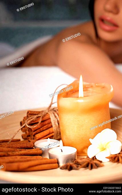 spa set with candle, flowers and cinnamon