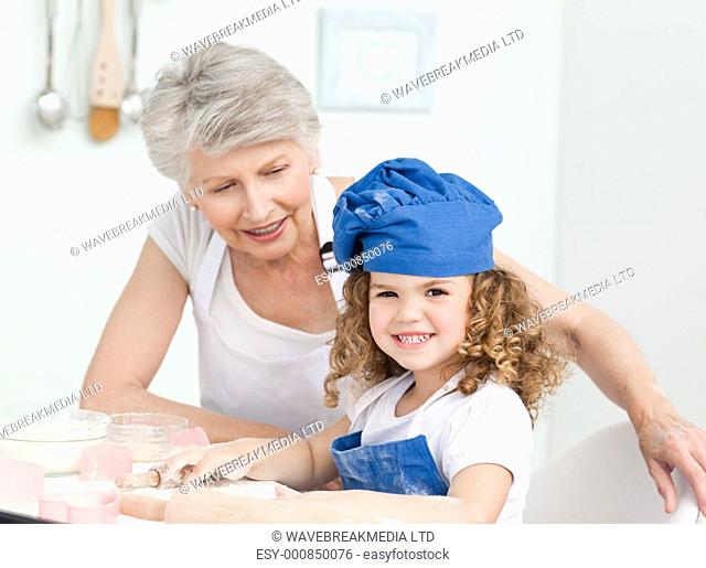 A little girl with her grandmother looking at the camera at home