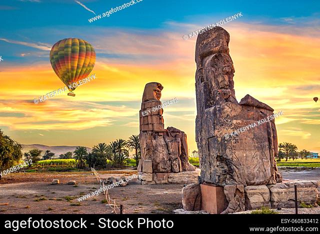 Hot air balloons and Colossus of Memnon in Luxor at sunrise, Egypt