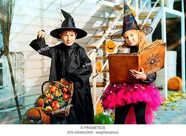 Happy children in a costumes of witches and wizards celebrating halloween. Trick or treat. Halloween party