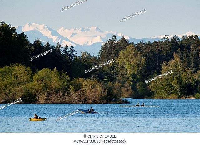Elk Lake, Olympics Mountains and fisherman and rowers, Saanich, British Columbia, Canada