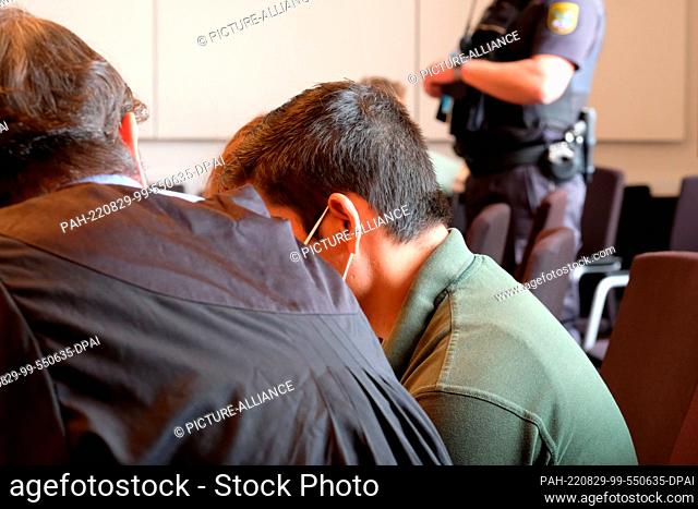 29 August 2022, Saxony-Anhalt, Halle: The defendant in a trial for attempted murder, sits in the dock at the regional court with his translator and lawyer