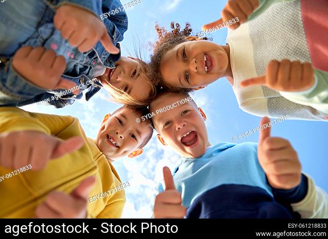 happy children showing thumbs up outdoors