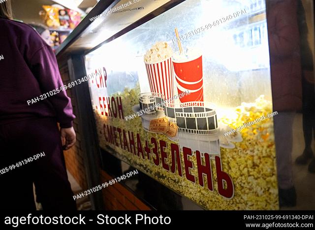 PRODUCTION - 20 October 2023, Ukraine, Irpin: Children queue for popcorn and drinks at a counter in the Perun cinema. The cinema was damaged during the attack...