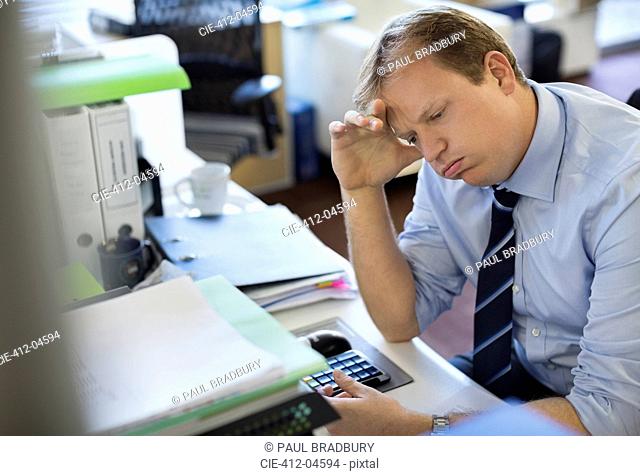 Businessman sighing at desk