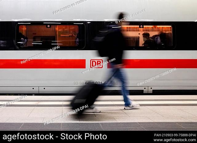 03 September 2021, Berlin: A passenger walks along an ICE train at Berlin central station. (Motion blur due to long exposure time) Photo: Christoph Soeder/dpa