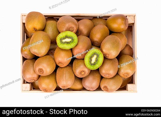 Wooden Box filled with many ripe Kiwi fruits and two half fruits isolated in white background view from top