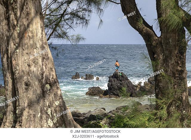 LaupÄ. hoehoe, Hawaii - LaupÄ. hoehoe Point. A man balances on rocks while fishing in the surf