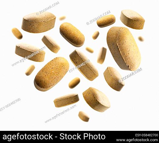 Yellow tablets in the shape of a heart on a white background