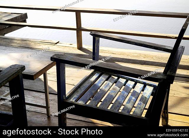 Wooden chairs on wood pier overlooking lake, stock photo
