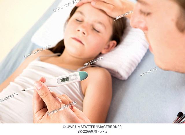 Fever, a pediatrician reading a digital fever thermometer showing concern about the high temperature of a young girl