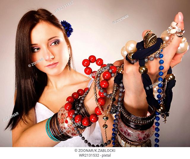 summer girl with plenty of jewellery, beads in hands