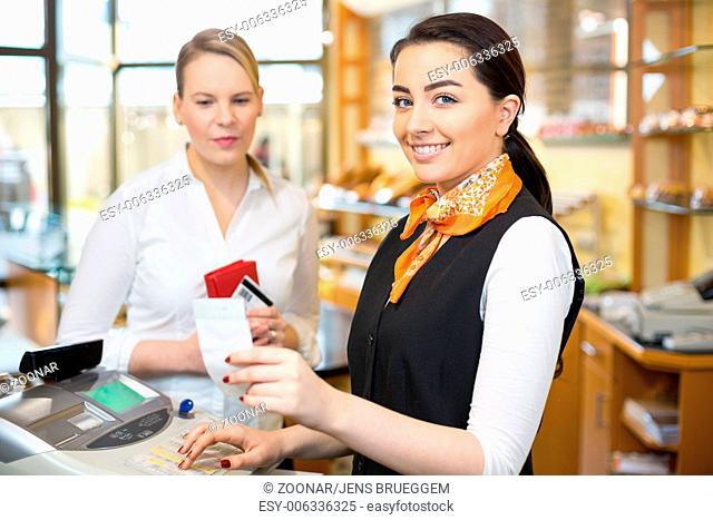Client at shop paying at cash register