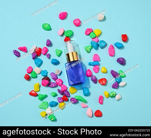 blue glass bottle with pipette on a blue background. Cosmetics SPA branding mockup, top view