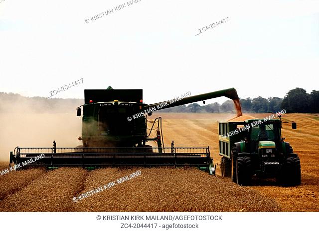 Harvester unloading the harvest to a tractor